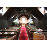 St Andrew, Greensted Church – Interior 1: An internal view of the chancel. Prior to the C16, the chancel was built of wood. It pre-dated the nave, and would originally have been the only part of the building. It would have been of a more primitive construction than the nave. Around 1500 A.D., during the reign of Henry VII, great changes were made to the church. The chancel was rebuilt in brick, and the thatched roof on both the nave and chancel was replaced by tiles. Dormer windows were added to the nave.