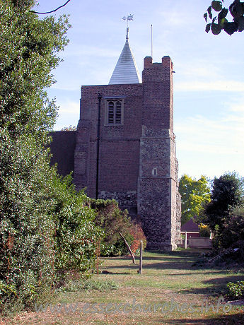 St Giles & All Saints, Orsett Church – The W tower occupies the westernmost bay of the N aisle. It is partly stone, and partly C17 brick. It has a large diagonal buttresses, and as can be seen in this picture, a bulky NW stair-turret. At the top it sports a white weather-boarded spire.