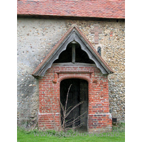 Dedication Unknown, Mashbury Church – Exterior 2: This tudor brick porch was built approx 1500. The roof of both this porch, and the nave are C15. Note the obsured Norman window, and the cross shape, formed from tiles.