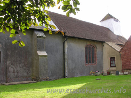 St James, Little Clacton Church – The N side of the church, showing a brick window (likely C16) in the nave wall.