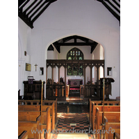 All Saints, Nazeing Church – Interior 2: The chancel arch, with screen. The two strange objects to either side of the arch are the remains of the rood screen supporting structure. Higher, and to the left, can be seen the remains of the rood beam.