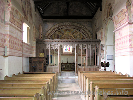 St Michael & All Angels, Copford Church – Looking towards the chancel, from the W end of the nave. Clearly visible here are four springers, which once supported the Norman barrel vaulting. Two can be seen either side of the screen, whilst the other two are clearly visible at both upper corners of the image.