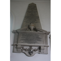 St Mary & All Saints, Lambourne Church – Monument 3: UPPER INSCRIPTION Near this place lye the remains of Mrs Matilda Lockwood, daughter of George Vernon Esq of Sudbury in Derbyshire; by Catherine daughter of Sir Thomas Vernon Kt, and wife of Richard Lockwood Esq of Dews-Hall in this parish: with whom she liv'd in all conjugal affection 31 years, and had a numerous offspring; of which five sons and two daughters are now living. To her husband she indear'd herself by every act of Kindness & Condescension. To all her children by an attentive, impartial care of them, with a prudent, not indulgent, tenderness to her relations she was respectful with her friends. Remarkably cheerful, open and sincere; To all mankind affable, to her inferiors very obliging and by all who knew her either near or at a Distance, she was esteem'd One of the most amiable and best of Women for she had all the advantage of a natural-charming Temper, Accomplish'd Behaviour, and good Understanding that could adorne this Life. And all the inward blessings of Christian Virtue and Piety which might intitle her to a Better. She dyed November ye 25th in ye Year of our Lord 1743 and the 54th of her Age. To whose memory her loving and mournful husband put up this Marble as ye last tribute of his Esteem. LOWER INSCRIPTION Be it Sacred Likewise, To the memory of Richard Lockwood Esq, second son of Richard Lockwood Esq of Gayton in Northamptonshire; by Susannah, daughter & sole heiress of Edward Cutts Esq. Early in life he went to Turkey to improve his fortune; But his Elder Brother Dying to whose Estate he was Heir, he return'd to England, & being of an Active Disposition, not only Carried on an Extensive Traffic for some Years, But being chosen into Several Parliaments, gave a Constant Attendance; Serving his Country & Constituents with an untainted Integrity, & unshaken Firmness, in the Decline of Life, thinking himself incapable of doing his Country any Farther Publick Service, he retir'd from the Fatigues of Busyness to his seat at DEWS-HALL; & Past the last Scene of his Life in a Chearfull enjoyment if his Family & Friends, And a truly religious Service of his God. Thus prepared he arrived at that period of Life, which at best, is but labour & sorrow, and by a gradual decay, Expir'd on the 31st day of August 1756, in the 78th Year of his age.
